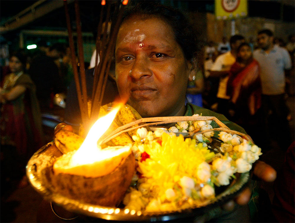 A Hindu devotee offers a prayer in front of the Lord Murugan's chariot  during a procession to mark the start of Thaipusam, an annual festival  symbolizing the struggle between good and evil in Kuala Lumpur,  Malaysia, early Monday, Feb. 6, 2012. The...
