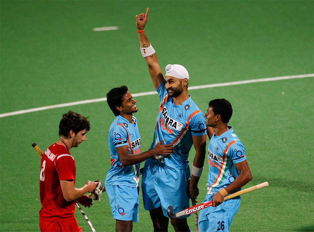 Indian players, Sandeep Singh, second right, Birendra Lakra, right, and  Danish Mujtaba, third right, celebrate as Sandeep scores the fourth goal  against Poland during field hockey Olympic qualifier in New Delhi,  India, Friday, Feb. 24, 2012. On th...
