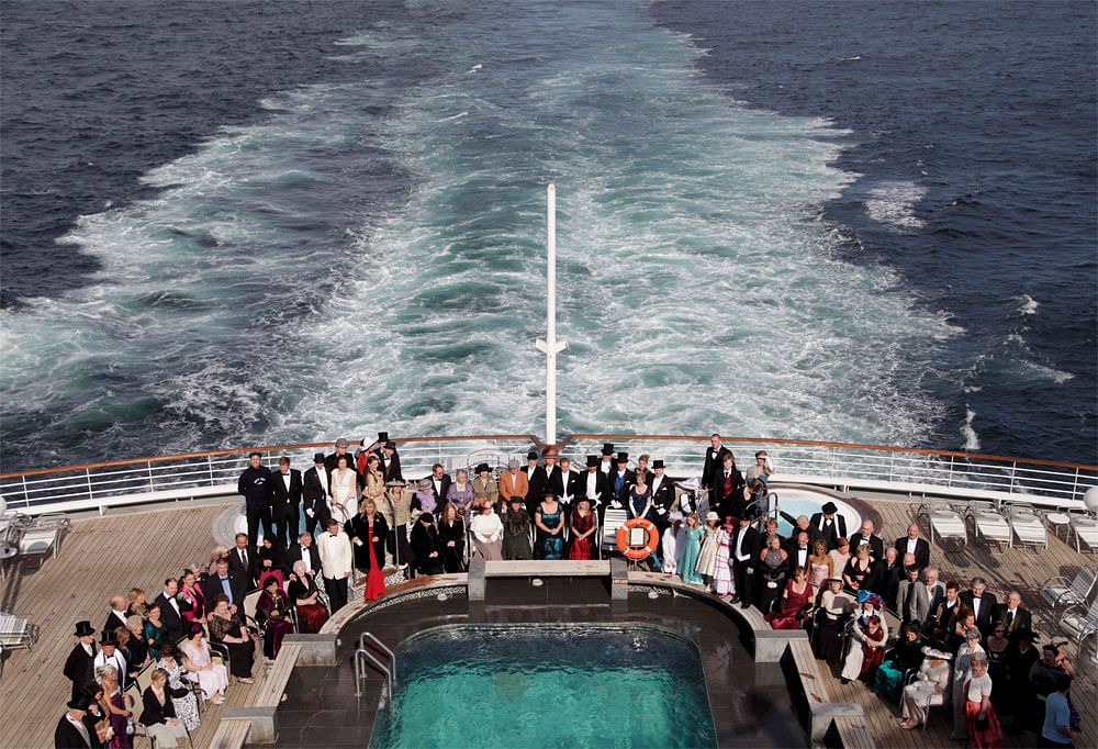 Passengers, some in period costumes and evening dresses, pose for a  group photo on the deck of the MS Balmoral Titanic memorial cruise ship,  in the Atlantic Ocean, en route to New York, Wednesday, April 18, 2012.  Exactly 100 years after the Titani...