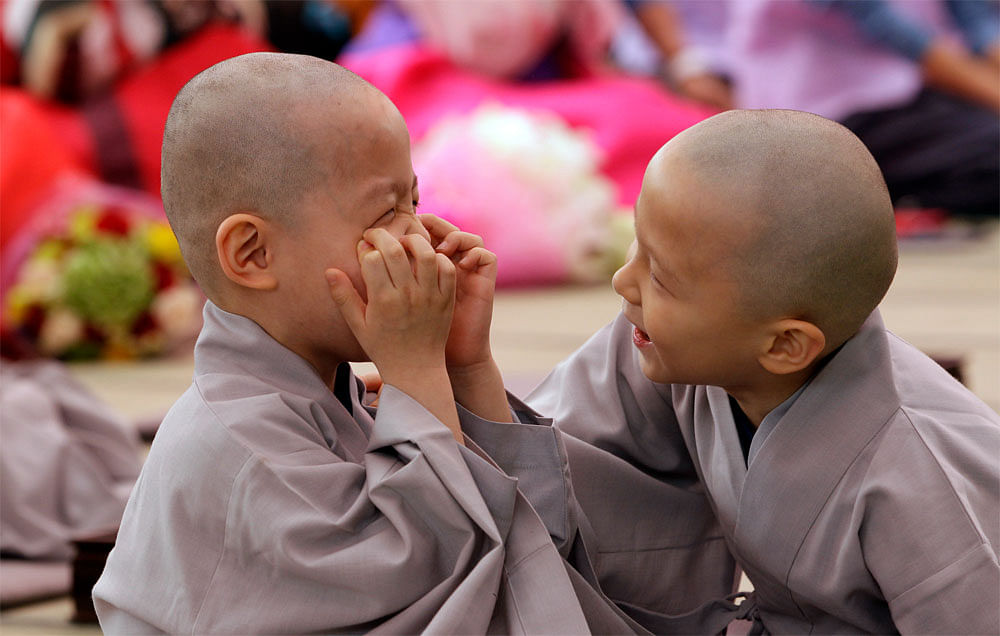 Shaven-headed young boys play with each other during a service to  celebrate Buddha's upcoming birthday at Jogye temple in Seoul, South  Korea, Sunday, May 13, 2012. They are some of the nine children who  entered the temple to have an experience of ...