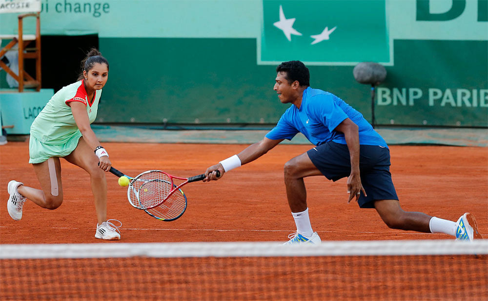 India's Sania Mirza, left, and Mahesh Bhupathi play Poland's Klaudia Jans-Ignacik and Mexico's Santiago Gonzalez in their mixed doubles final match of the French Open tennis tournament at the Roland Garros stadium in Paris, Thursday, June 7, 2012. Th...