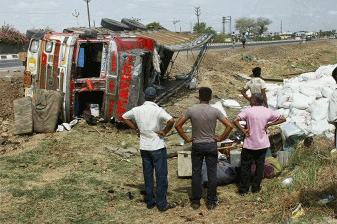People looking at the ill-fated truck the overturned on the Sanand-Viramgam Highway, in Ahmedabad on Thursday.