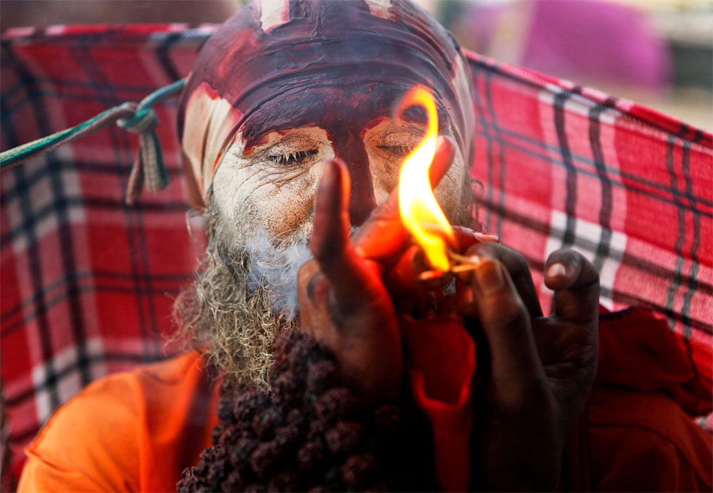 A sadhu smokes tobacco at the Sangam, the confluence of the rivers Yamuna, Ganga, and Saraswati, in Allahabad on Friday, July 6, 2012. AP Photo