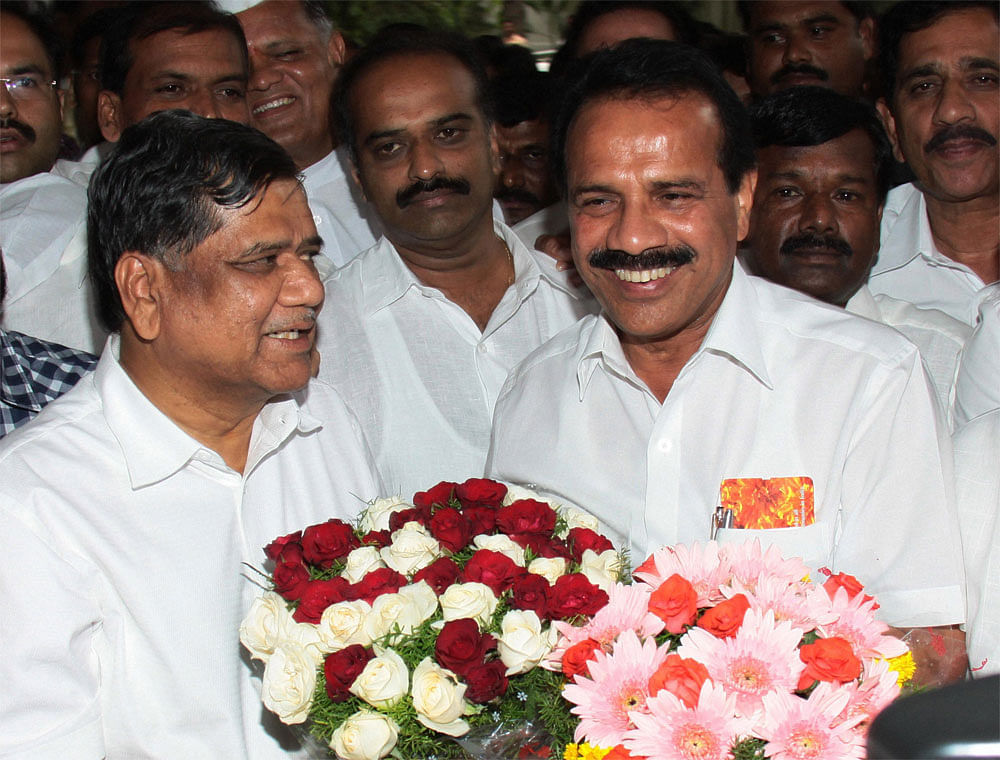 Karnataka Chief Minister D V Sadananda Gowda exchanges flower bouquet with Jagadish Shettar after he was nominated as new Karnataka CM by BJP President Nitin Gadkari, at his residence in Bengaluru on Sunday. PTI Photo