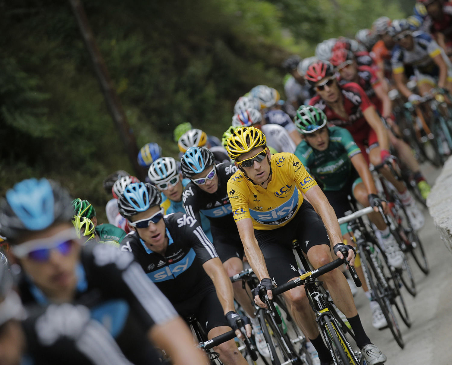 Bradley Wiggins of Britain, wearing the overall leader's yellow jersey, rides in the pack during the 14th stage of the Tour de France cycling race over 191 kilometers (118.7 miles) with start in Limoux and finish in Foix, France, Sunday July 15, 2012...