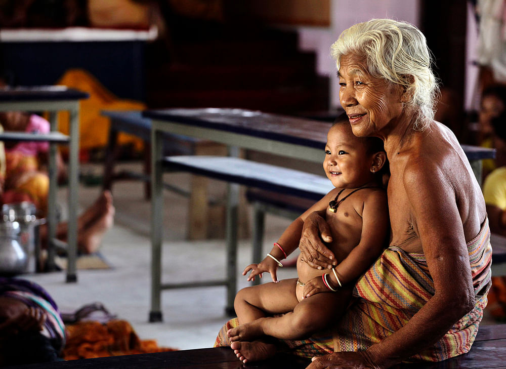 An elderly Bodo woman holds a baby inside a camp during Indian Prime Minister Manmohan Singh's visit, in Kokrajhar, India, Saturday, July 28, 2012. Singh has promised help for hundreds of thousands of survivors of brutal ethnic rioting in the country...