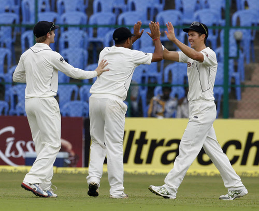 New Zealand's Trent Boult (R) celebrates with teammates after taking a  catch off the bowling of teammate Tim Southee to dismiss India's  Cheteshwar Pujara during the second day of their second test cricket  match in Bangalore, September 1, 2012. REU...