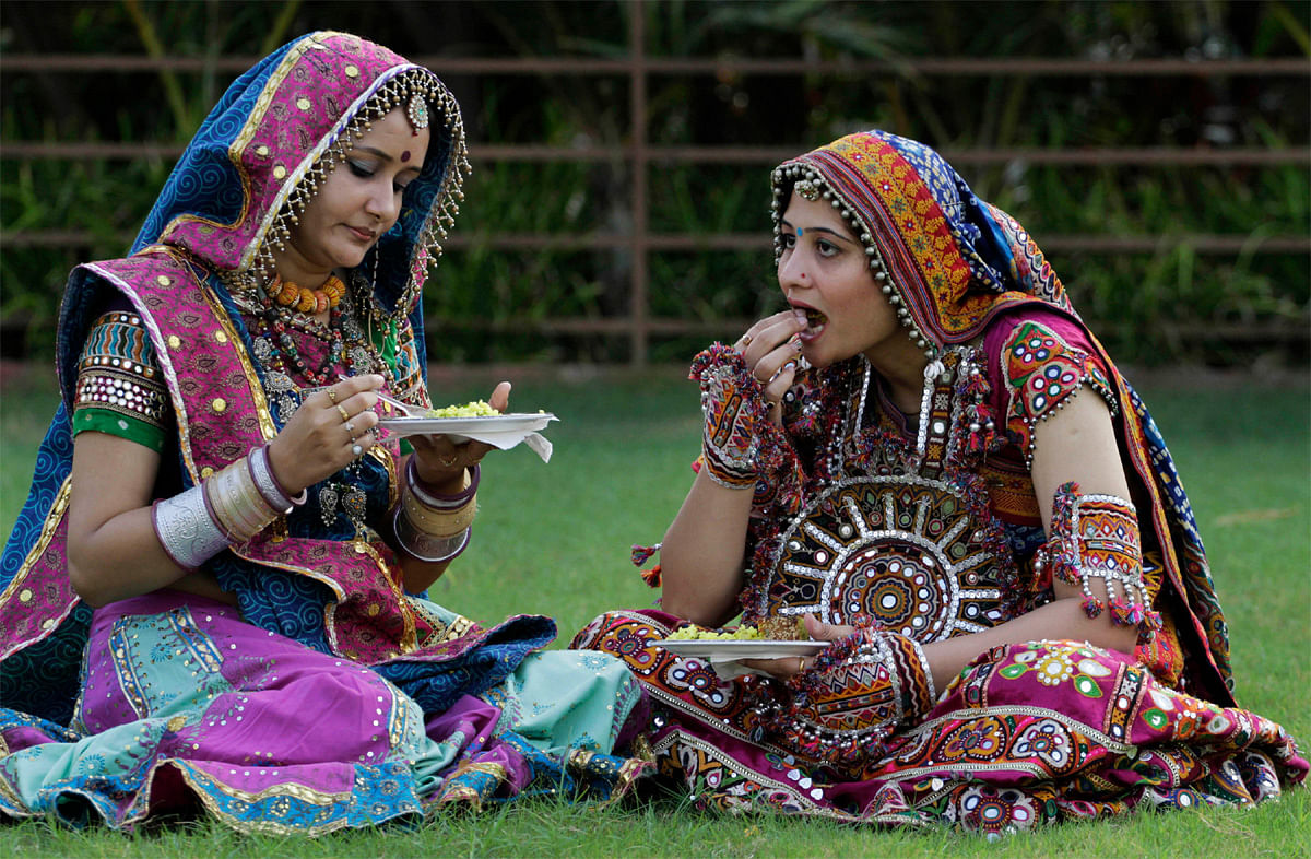 Indian women in traditional attire have breakfast after a practice session of Garba, a traditional dance of Gujarat ahead of Navratri festival in Ahmadabad, India, Sunday, Oct. 7, 2012. Navratri, or the festival of nine nights will begin from Oct. 16...