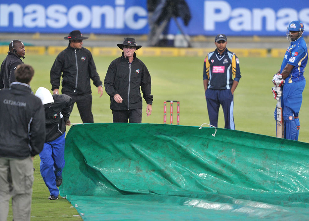Groundsmen prepare the covers as rain delayed play during Match 11 of The Champions League T20 (CLT20) between the Mumbai Indians (India) and Yorkshire (England) at Newlands Cricket Stadium in Cape Town on October 18, 2012. AFP PHOTO /Luigi Bennett