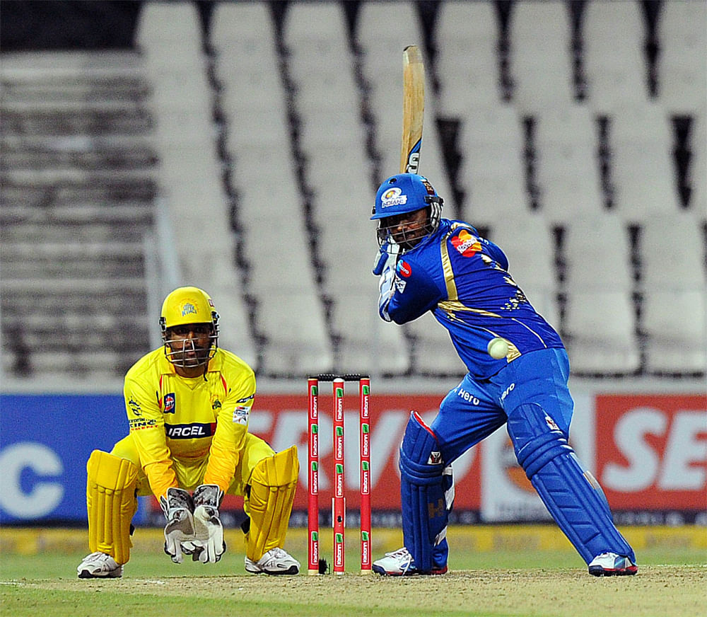 Mumbai Indians batsman Harbhajan Singh (R) lines up a shot as Chennal Super Kings wicketkeeper Mahendra Singh Dhoni (L) waits to make a catch on October 20, 2012 during a Group B Champions League T20 (CLT20) match at Wanderers Stadium in Johannesburg...