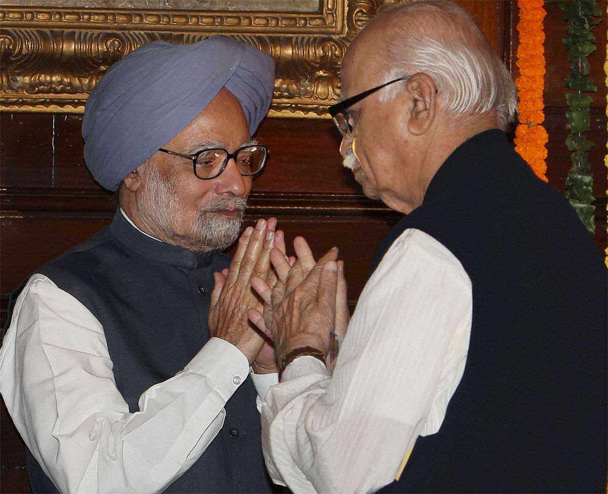 Prime Minister Manmohan Singh exchanges greetings with senior BJP Leader L K Advani after paying homage to Sardar Vallabhbhai Patel on his birth anniversary at Parliament in New Delhi on Wednesday. PTI Photo