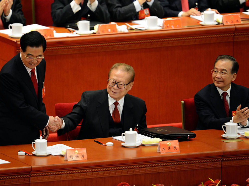 Chinese President Hu Jintao (L) shakes hands with former president Jiang Zemin (C) as Premier Wen Jiabao (R) looks on, at the opening of the 18th Communist Party Congress at the Great Hall of the People in Beijing on November 8, 2012. Xi had moved cl...