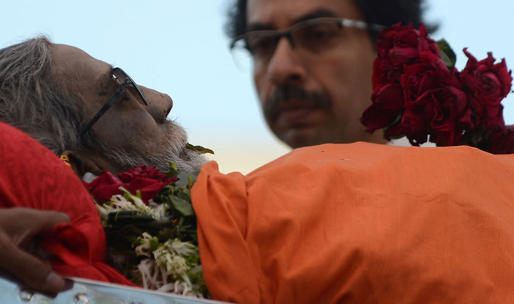The body of Leader of Indian Hindu nationalist Shiv Sena party Bal  Thackeray is watched by his son Uddhav Thackeray (R) makes way through a  sea of supporters during a funeral procession in Mumbai on November 18,  2012.   Huge crowds gathered in Mum...