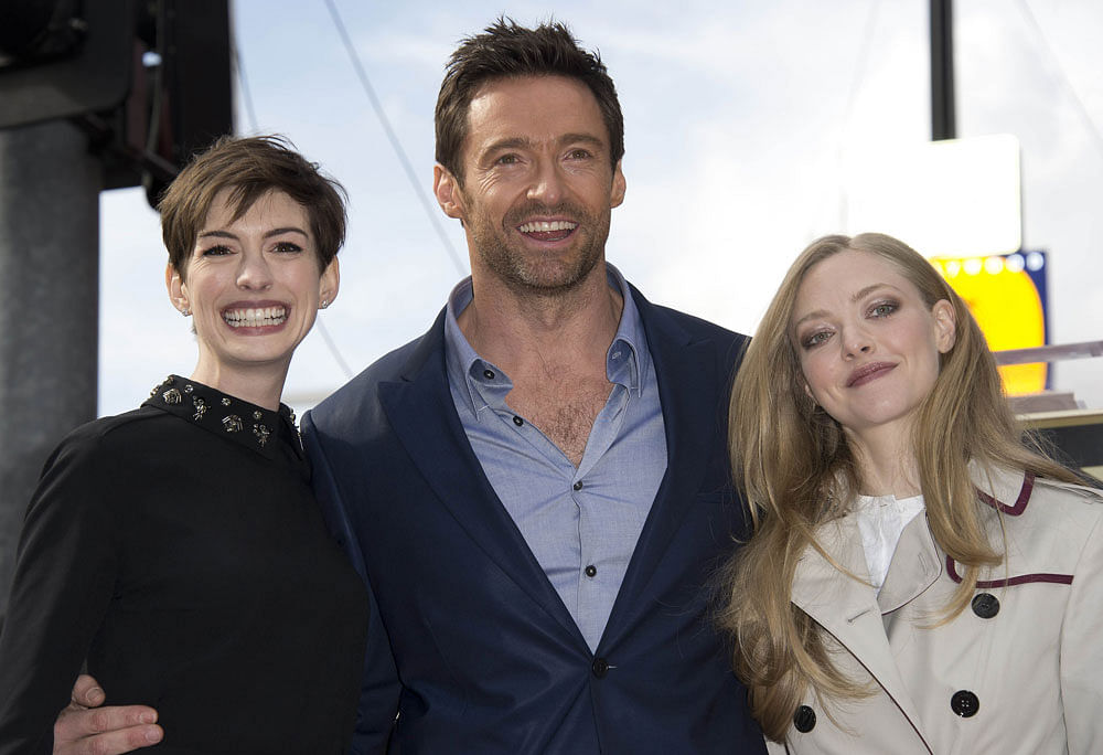 Actor Hugh Jackman poses with his actresses Anne Hathaway (L) and Amanda Seyfried at his star on the Hollywood Walk of Fame after the star was revealed at an unveiling ceremony, December 13, 2012 in Hollywood, California. AFP