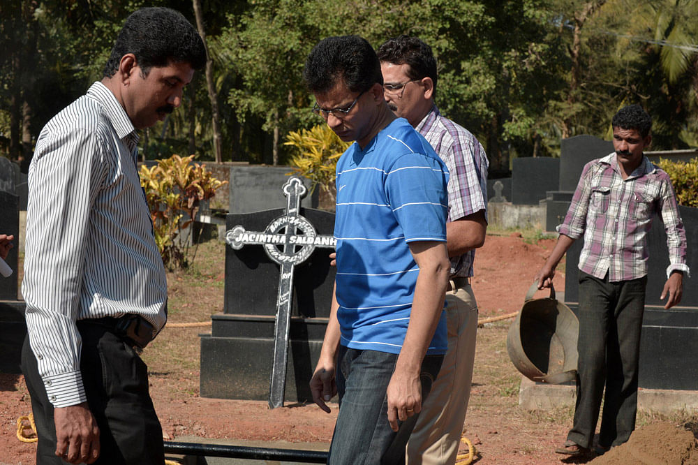 Benedict Barbosa (C), husband of late Indian nurse Jacintha Saldanha,   arrives to  inspect the preparations of her grave at The Shirva Church  Cemetery, near Mangalore on December 16, 2012.  Family and friends of  the nurse who was found hanged afte...