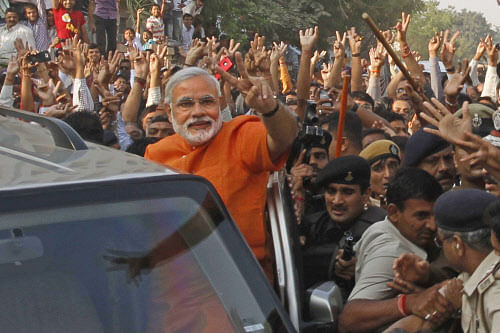 Gujarat state Chief Minister Narendra Modi, center, greets his supporters after casting his vote in the second phase of the state assembly elections in Ahmadabad, India, Monday, Dec. 17, 2012. AP