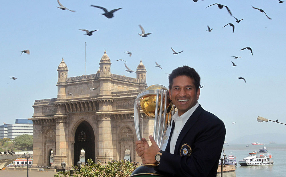 In this photograph taken on April 3, 2011, Indian cricketer Sachin  Tendulkar poses with the ICC Cricket World Cup trophy with the Gateway  of India monument in the background during a photo call at the Taj Mahal  hotel in Mumbai. India's record-brea...