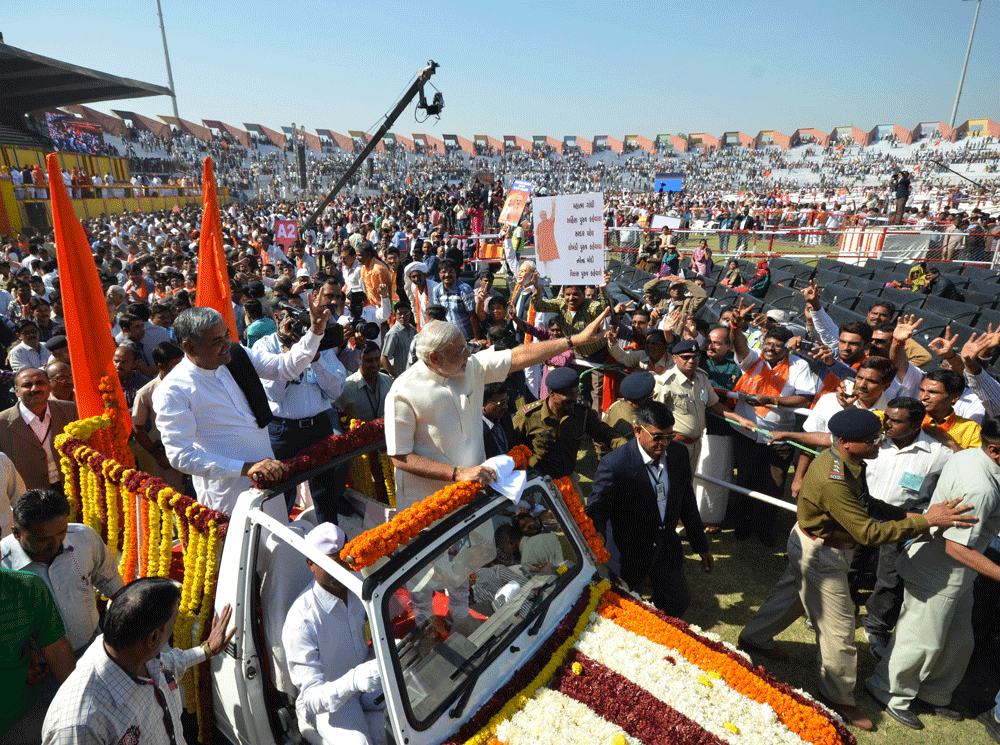 Chief Minister of the western Indian state of Gujarat Narendra Modi (C) waves to supporters after his swearing in ceremony at The Sardar Patel Navrangpura Stadium in Ahmedabad on December 26, 2012. Modi who won a landslide victory in recent state ass...