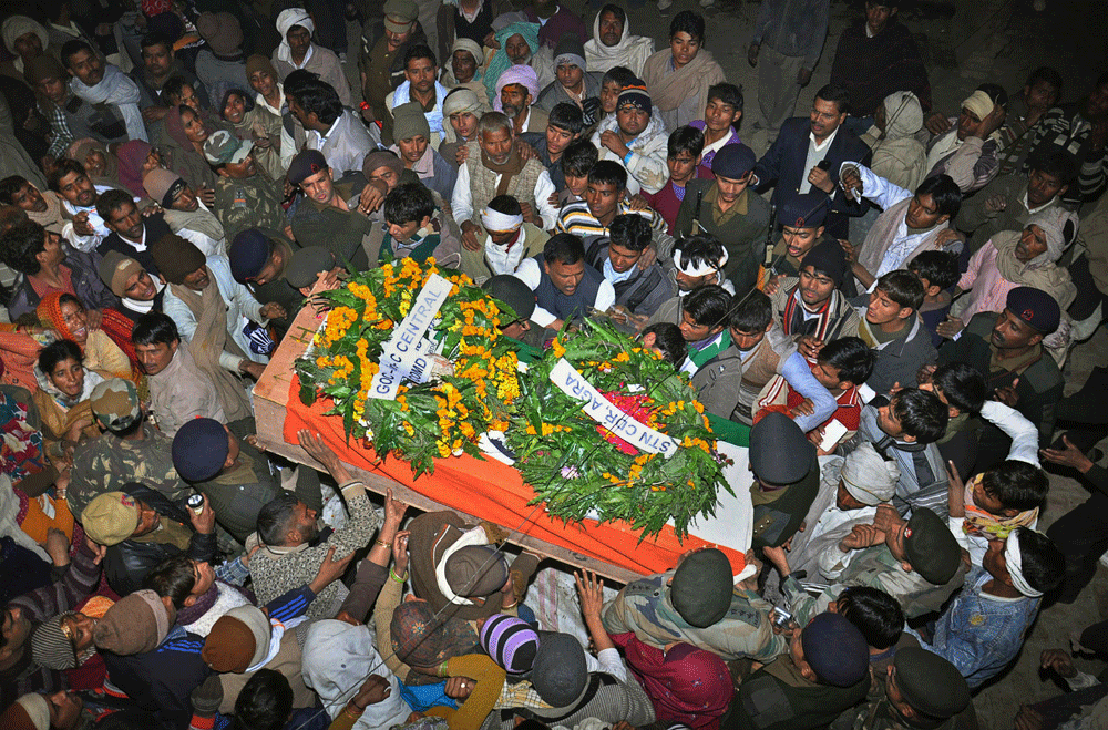 Mourners gather around the body of Indian Army soldier Lance Naik Hamraj who was allegedly killed by Pakistani soldiers on the line-of-control in Kashmir, during his funeral in Mathura district, Utter Pradesh state, northern India, Wednesday, Jan. 9,...