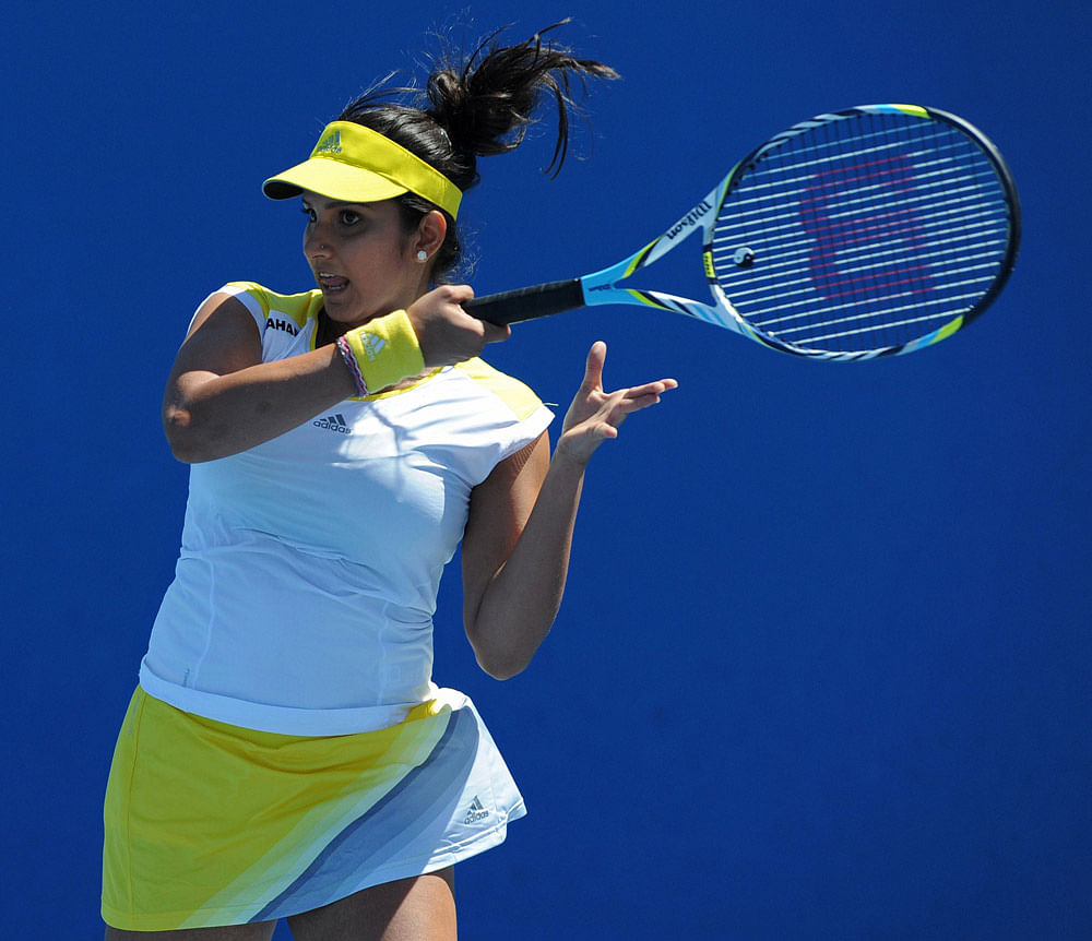 India's Sania Mirza plays a return during her women's doubles match with Bethanie Mattek-Sands of the US against Spain's Silvia Soler-Espinosa and Carla Suarez-Navarro on the third day of the Australian Open tennis tournament in Melbourne on January ...