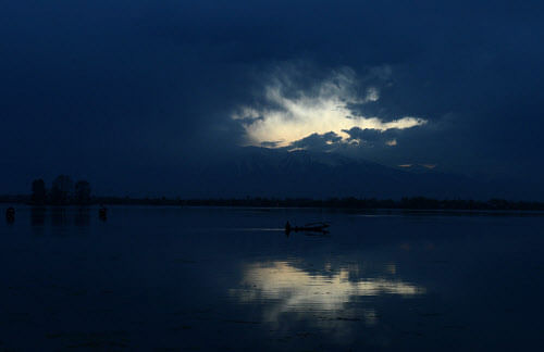 A boat sails at sunset on Dal Lake in Srinagar on March 27, 2013. Kashmir is divided between nuclear-armed rivals India and Pakistan, with both claiming the disputed territory in its entirety. Armed rebels have fought Indian security forces in Kashmi...