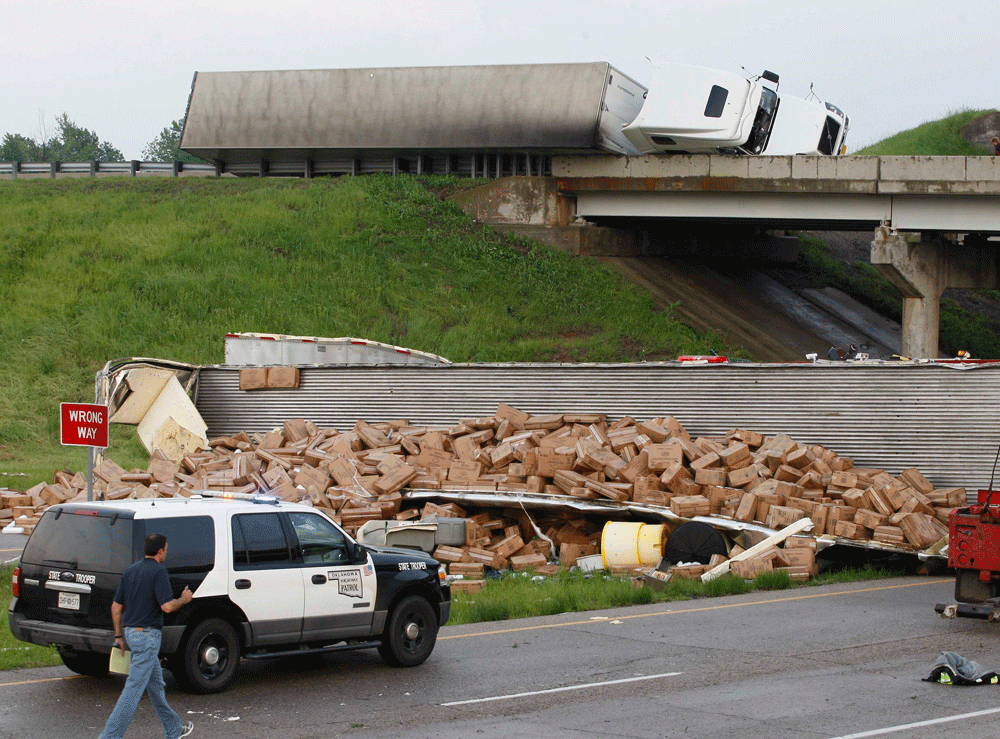 A semi-tractor trailer (top) rests on its side against the guard rails on Interstate 40 as another trailer lies broken open on the road below after falling from I-40, following a tornado strike near Highway 177 north of Shawnee, Oklahoma May 19, 2013...