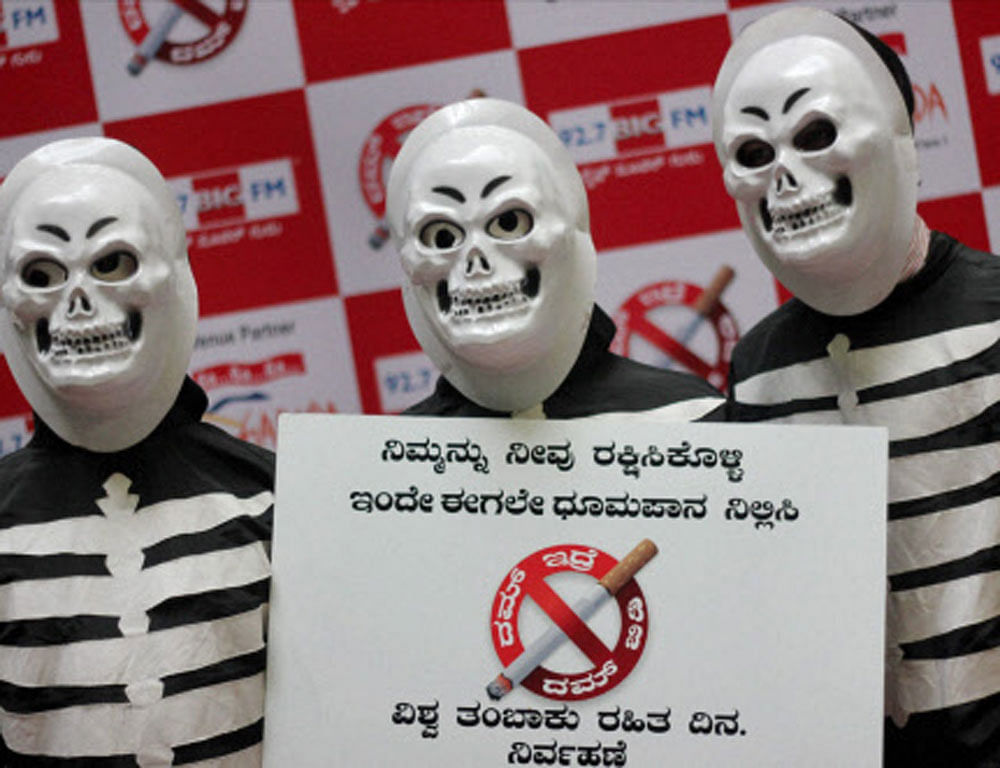 Volunteers wear skeleton dress as they hold a anti tobacco poster to mark the 'World No Tobacco Day' in Bengaluru on Friday. PTI Photo