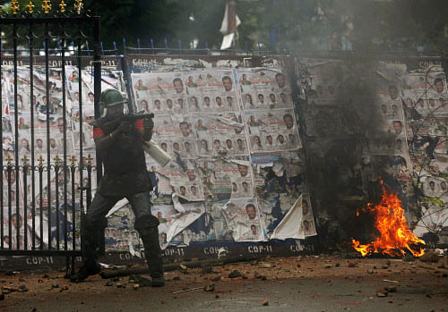 A policeman fires tear gas shells at students during a protest demanding  creation of a new state named “Telangana” in Hyderabad, India, Friday,  June 14, 2013. The protesters have been demanding that the new state be  carved out of the existing ...