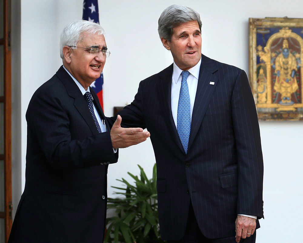 Indian Foreign Minister Salman Khurshid, left, gestures to media as U.S. Secretary of State John Kerry looks on before their meeting in New Delhi, India, Monday, June 24, 2013. (AP Photo