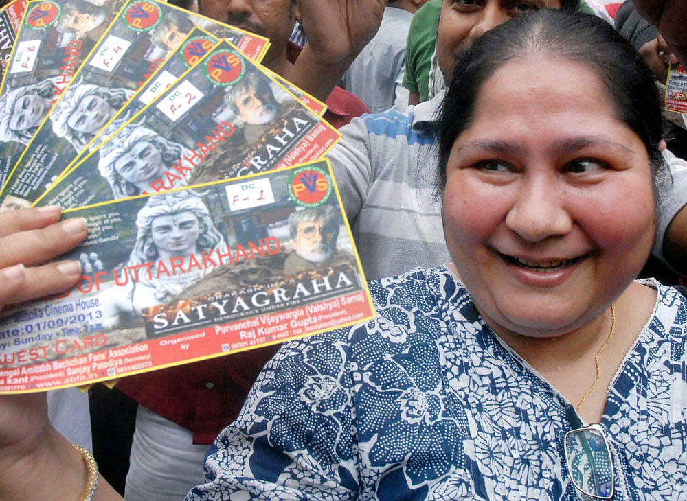 An Amitabh Bachchan fan displays her tickets of a special show of  'Satyagraha', for the cause of relief for the Uttarakhand's flood  victims in Kolkata on Sunday. PTI Photo