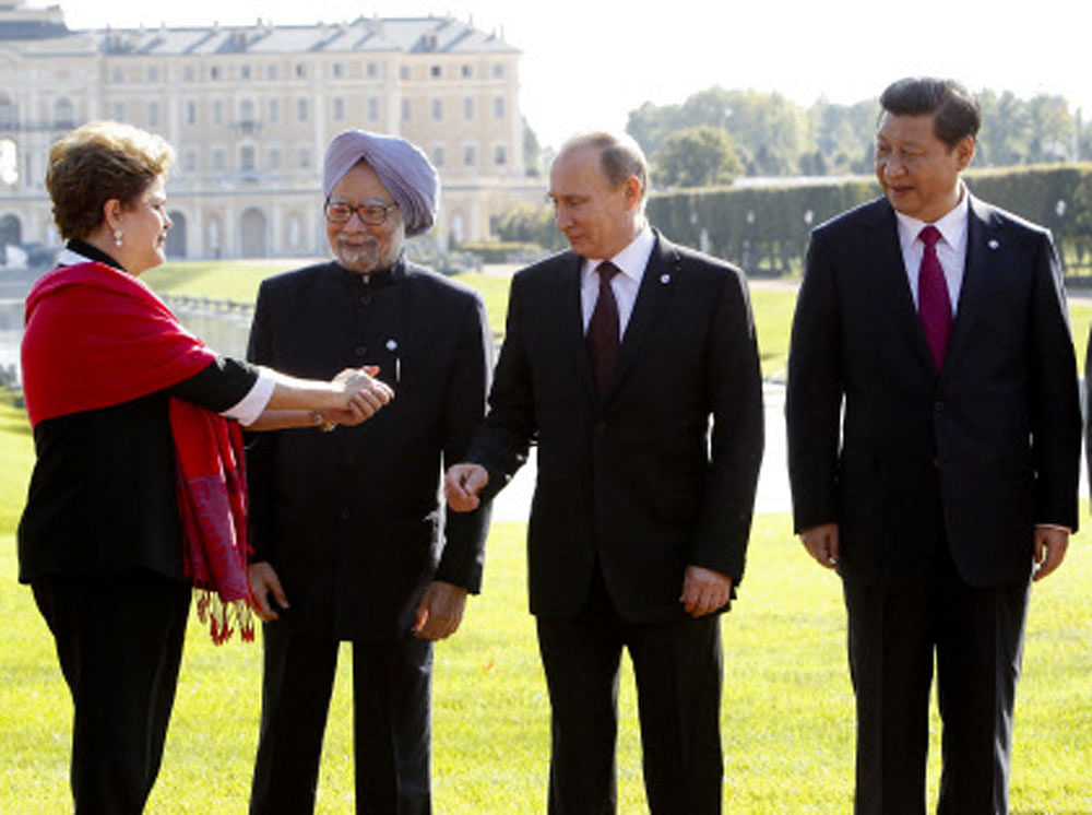 From left, Brazil's President Dilma Rousseff gestures to India's Prime Minister Manmohan Singh, Russia's President Vladimir Putin and China's President Xi Jinping as they gather for a group photo after a BRICS leaders' meeting at the G-20 Summit in S...