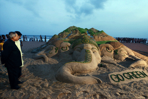 President Pranab Mukherjee having a look of a sand art on Lord Ganesh  with a message 'Go Green', created by artist Sudarsan Pattnaik, at Puri  beach on Friday. PTI Photo