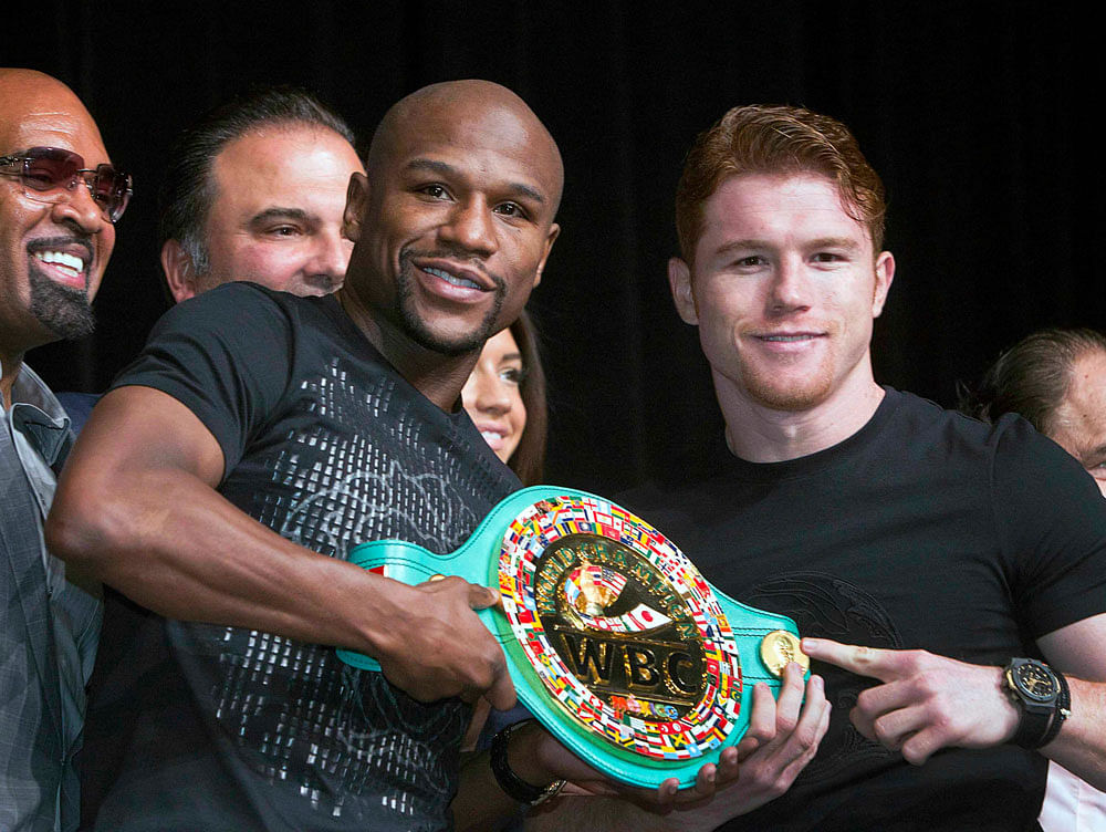 Undefeated boxers Floyd Mayweather Jr. (L) of the U.S. and Canelo Alvarez of Mexico pose with a WBC super welterweight belt during a news conference at the MGM Hotel and Casino in Las Vegas, Nevada September 11, 2013. Mayweather and Alvarez will meet...