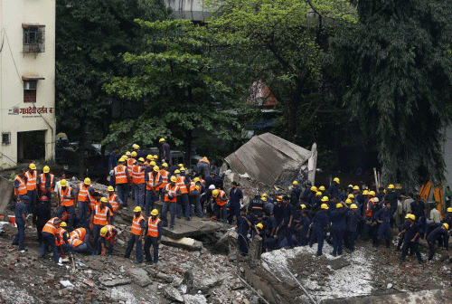 Rescue crews search for survivors at the site of a collapsed residential  building in Mumbai September 27, 2013. The five-storey apartment block  collapsed on Friday in the Indian financial centre of Mumbai, killing  one person with dozens feared tra...