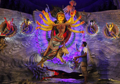 An artist applies the finishing touches on an idol of the Hindu goddess  Durga inside a marquee, ahead of the 'Durga Puja' festival, in Kolkata  October 3, 2013. The Durga Puja festival will be celebrated from October  11 to 14, and is the biggest re...