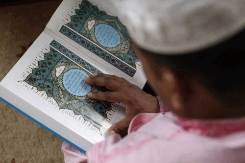 A Muslim reads in a mosque after Eid al Adha prayers in Singapore October 15, 2013. Muslims across the world celebrate the annual festival of Eid al-Adha or the Festival of Sacrifice, which marks the end of the annual hajj pilgrimage, by slaughtering...