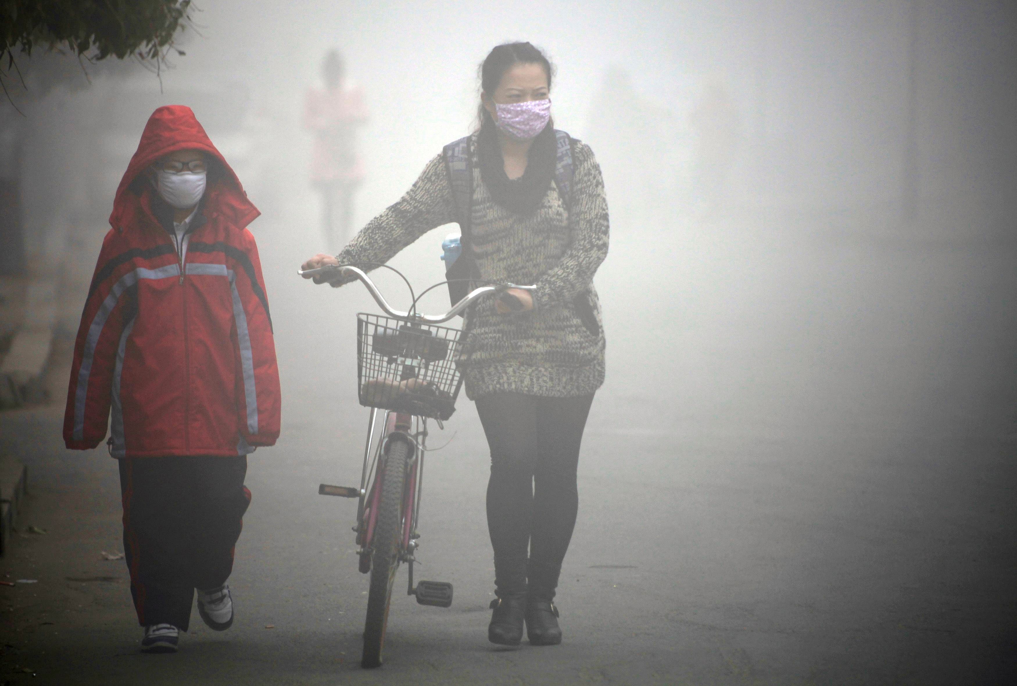 People walk along a street during a smoggy day in Jilin, Jilin province,  October 22, 2013. Air quality in Chinese cities is of increasing  concern to China's stability-obsessed leadership because it plays into  popular resentment over political priv...