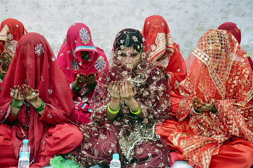 Muslim girls offering prayer during a mass marriage ceremony in Moradabad on Monday. PTI Photo