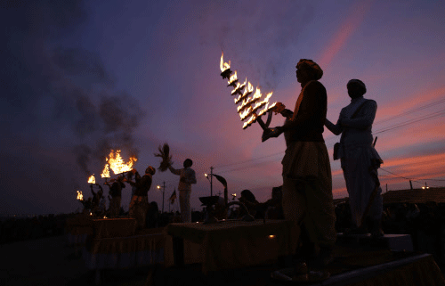 Priests rotate traditional oil lamps as they perform evening rituals at  the Sangam, the confluence of rivers Ganges, Yamuna, and mythical  Saraswati rivers, during the annual traditional fair 'Magh Mela' in  Allahabad, India, Tuesday, Jan. 28, 2014....