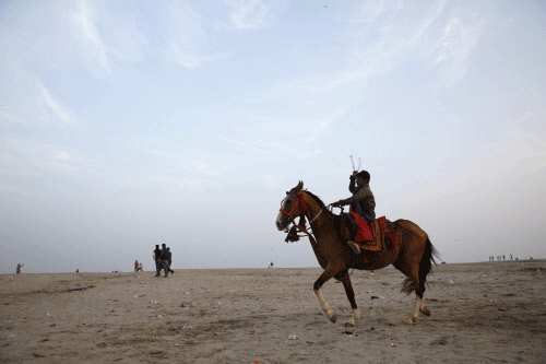 A horse and rider wait around to give rides to tourists on the banks of  the River Ganges in Varanasi India, Sunday, Feb. 2, 2014.  Varanasi is  among the world's oldest cities, and millions of Hindu pilgrims gather  annually here for ritual bathing ...