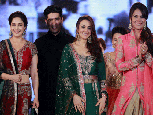 Bollywood actresses Madhuri Dixit, left, Lara Dutta right, and Prety Zinta wear designs by Indian designer Manish Malhotra, second left, during a fashion show to support the cause of saving and empowering the female child in Mumbai, India, Wednesday,...