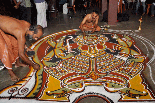 Artists drawing natural colour powder carpet during the International Folk Fest of Kerala 2014 at Kochi on Tuesday.PTI Photo