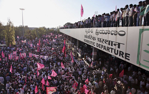 Supporters of Telangana Rashtra Samithi (TRS) chief K. Chandrasekhar Rao wait to welcome him at Begumpet domestic airport to celebrate the formation of separate Telangana state at a rally in Hyderabad, India, Wednesday, Feb. 26, 2014. The 29th Telang...