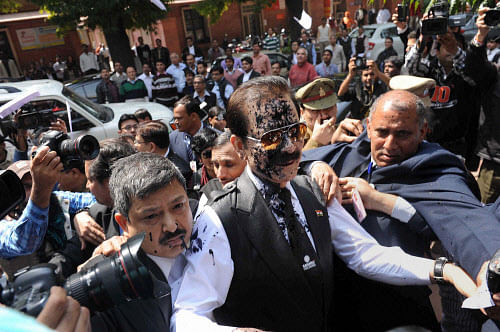 Chairman of Sahara India Pariwar Subrata Roy, with face smeared with ink  thrown by a lawyer, walks to appear before the Supreme Court in New  Delhi on Tuesday after a weekend in the UP police custody. PTI Photo