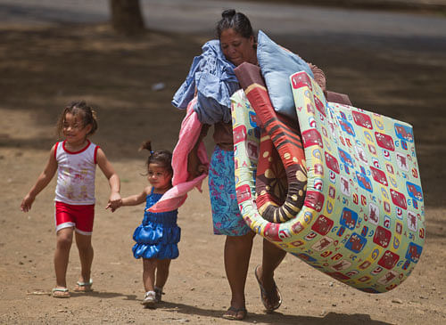 A woman carries mats to a shelter for people displaced by a 6.1-magnitude quake, in Managua, Nicaragua, Friday, April 11, 2014. Nicaragua's President Daniel Ortega declared a red alert Friday after the Thursday quake shook the country and left one de...
