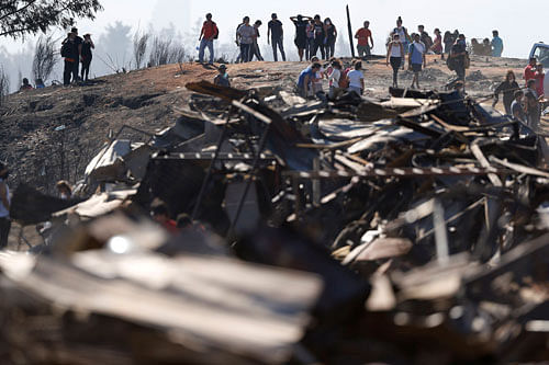 Residents remove debris from their burned houses after a fire burned several neighbourhoods in the hills in Valparaiso city, northwest of Santiago April 14, 2014. Devastated Chileans surveyed damage to their homes in Valparaiso on Monday as a massive...