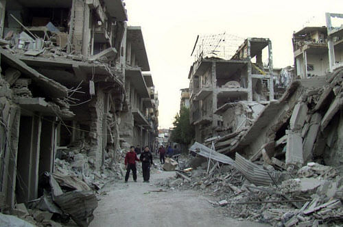 This file photo released on Thursday Nov. 29, 2012 by the anti-government activist group Homs City Union of The Syrian Revolution, which has been authenticated based on its contents and other AP reporting, Syrian citizens walk in a destroyed street t...