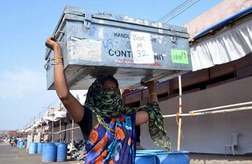 Nagpur: A labourer carries a box contaning election counting material at a counting center in Nagpur on Wednsday. PTI Photo