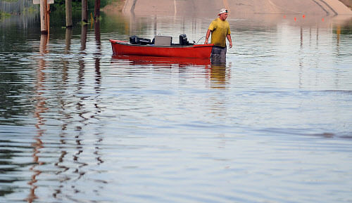 A man uses a boat to remove items from a business in Greeley, Colo., Monday, June 2, 2014. About 200 homes and businesses received a voluntary evacuation notice just before midnight Sunday. (AP Photo)