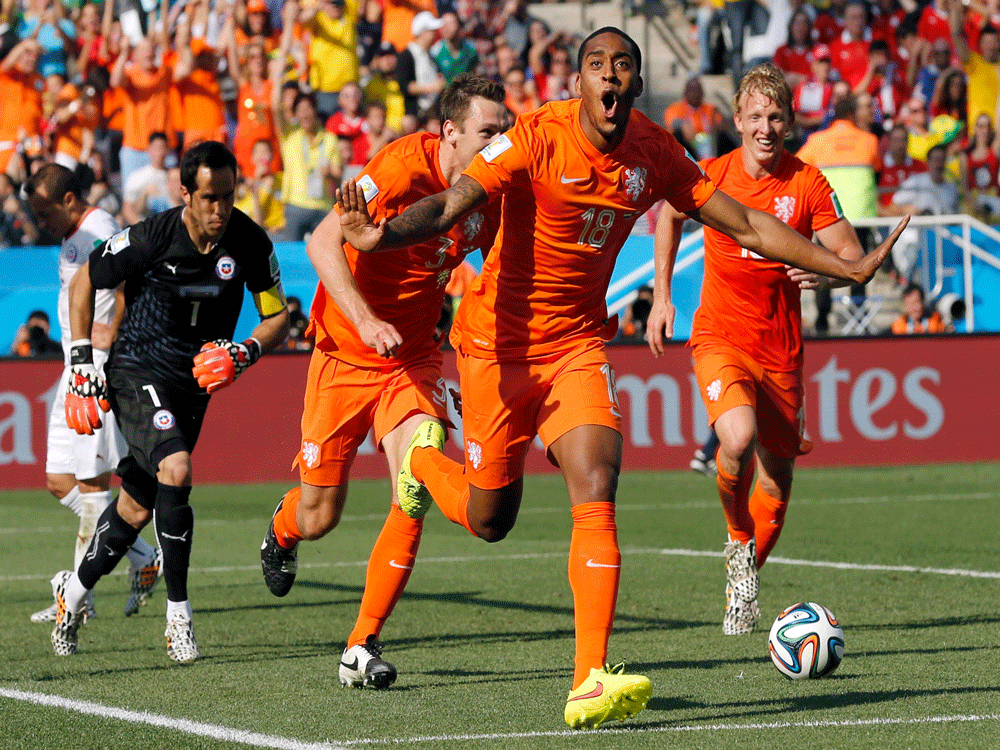 Netherlands' Leroy Fer, center, celebrates scoring the opening goal during the group B World Cup soccer match between the Netherlands and Chile at the Itaquerao Stadium in Sao Paulo, Brazil, Monday, June 23, 2014. AP Photo
